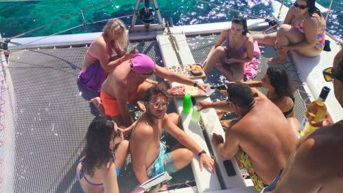 Ragazzi mentre prendono il sole a bordo del catamarano durante il tour nella costa nord-est della Sardegna