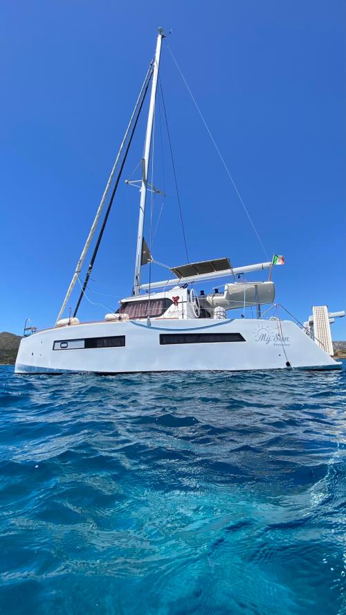 Mare turchese dell'Asinara e catamarano durante tour giornaliero con pranzo a bordo