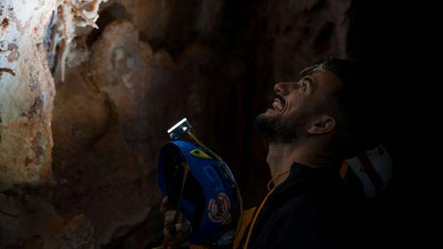 Escursionista osserva una parete all'interno della grotta Sa Nurre de Su Hoda a Oliena