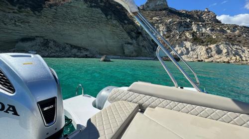 Gommone con tendalino nelle acque blu di Cagliari