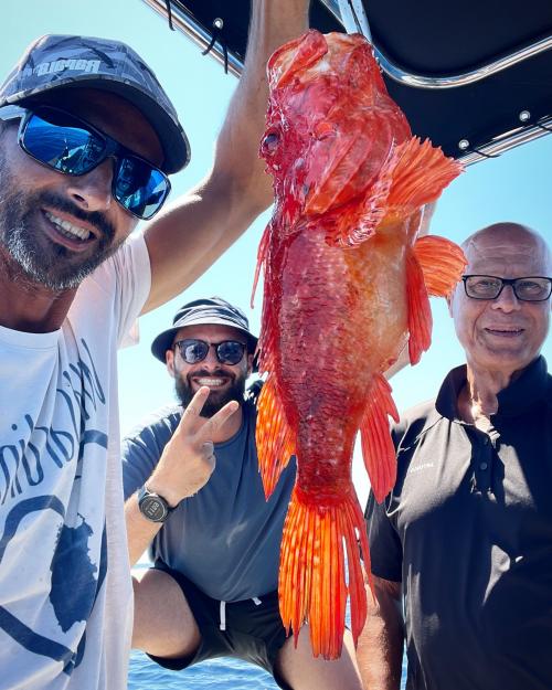 Pesce appena catturato a bordo di un gommone durante escursione di pesca con pescatore esperto locale