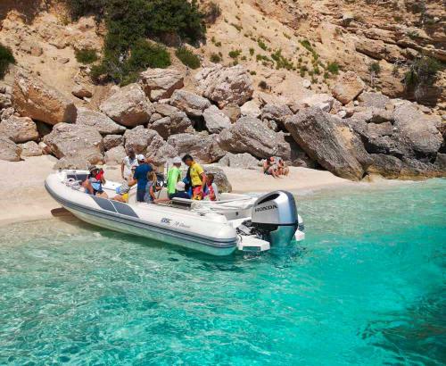 Gommone approda su una spiaggia con l'acqua azzurra del Golfo di Orosei