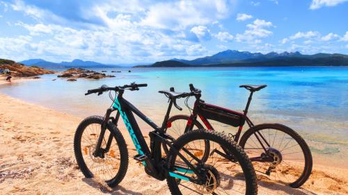Zwei Elektrofahrräder an einem Strand der Costa Smeralda