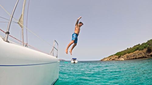 Ragazzo si tuffa dal catamarano nelle acque cristalline dell'Area Marina Protetta di Tavolara