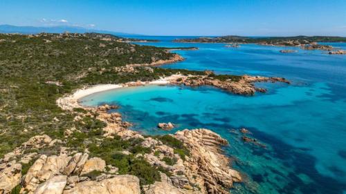 Blick von oben auf einen Strand mit blauem Wasser im La Maddalena Archipelago