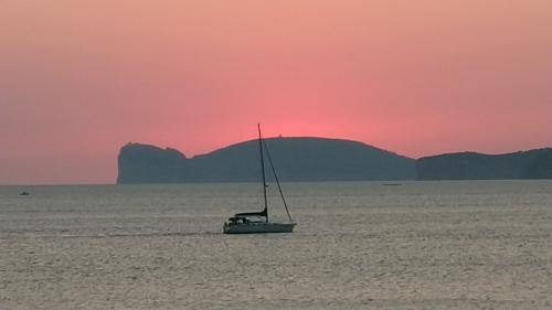 Sunset on the promontory of Capo Caccia and sailing in the waters of Alghero