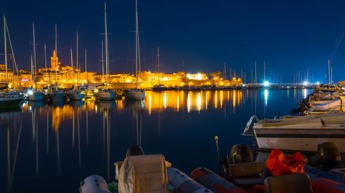 Hafen von Alghero bei Nacht mit Lichtern beleuchtet