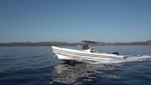 Schlauchboot mit Skipper navigiert durch die Gewässer des Archipels von La Maddalena während eines Ausflugs am Morgen oder am Nachmittag