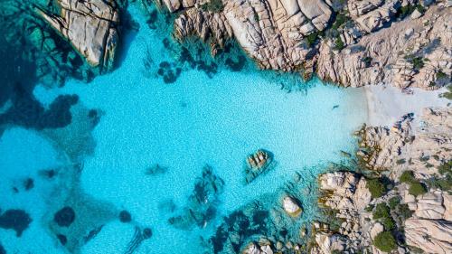 Das kristallklare Meer von Cala Coticcio, in dem Sie während der Schlauchbootfahrt schwimmen können