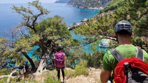 A group of hikers during a guided walk with a view of the sea in the Gulf of Orosei