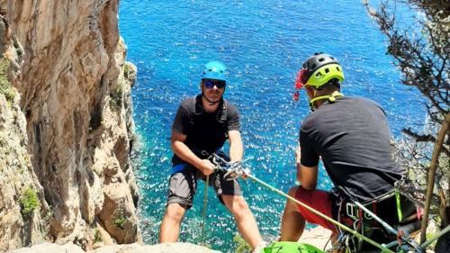 Boy during abseiling with guide and equipment