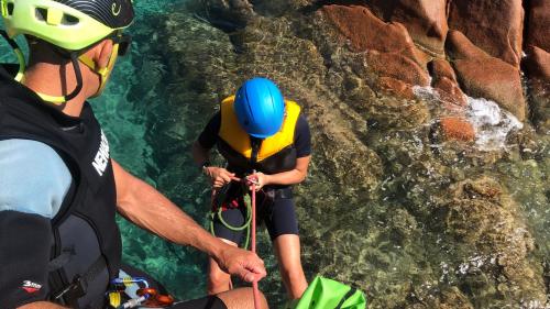 Junge mit Ausrüstung macht eine geführte Seilklettertour im blauen Meer im Osten Sardiniens