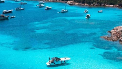 Boote im kristallklaren Wasser des Archipels von La Maddalena