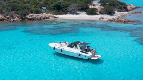 Motorboot mit Menschen an Bord in den Gewässern des Archipels von La Maddalena