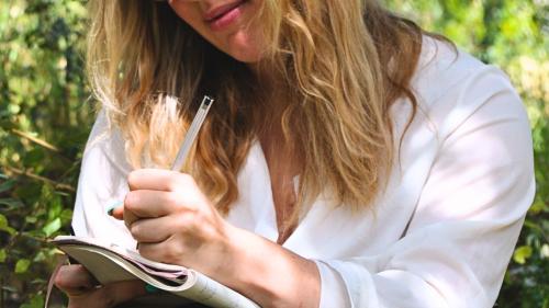 Une randonneuse énumère ce dont elle est reconnaissante dans un carnet lors d'un exercice dans la nature à Perfugas.