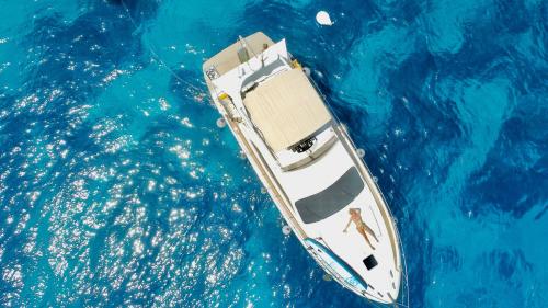 Girl sunbathing on board of the yacht in Villasimius