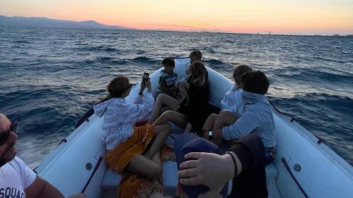 Eine Gruppe von Menschen während einer Schlauchbootfahrt bei Sonnenuntergang in den Gewässern von Cagliari