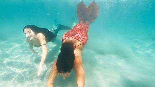 Mädchen schwimmen im türkisfarbenen Meer von Cagliari wie Meerjungfrauen 