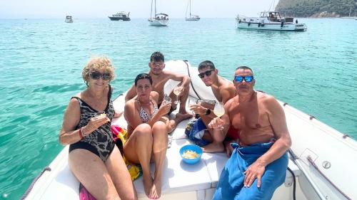 People on board the dinghy eating snacks in the waters of southern Sardinia