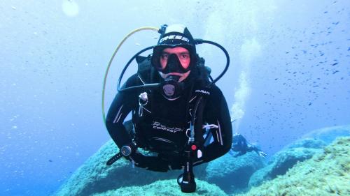 Persona durante l'immersione nel fondale marino roccioso a Cagliari