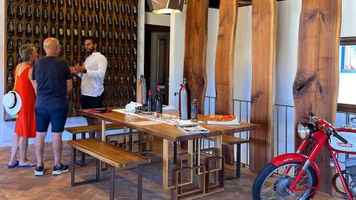 Two participants listen to the host's explanation of wines