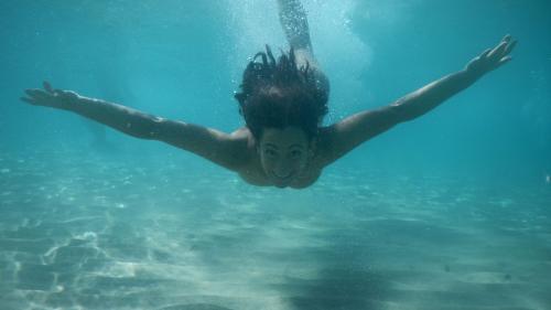 Girl swimming in the crystal-clear waters of the Gulf of Orosei