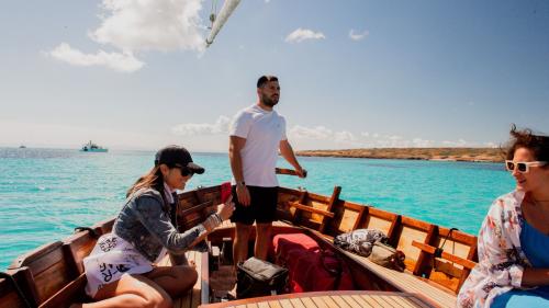 Menschen an Bord des Bootes während der privaten Tour durch die kristallklaren Gewässer von Stintino