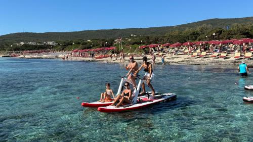 Familie mietet zwei Wasserfahrräder im Meer bei Stintino