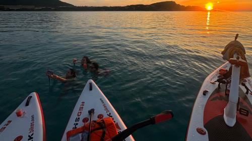 Wasserfahrräder und Menschen bei Sonnenuntergang in den Gewässern der Pelosa