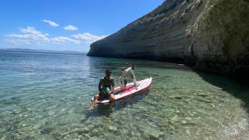 Garçon assis sur un vélo aquatique lors d'une location en mer à Stintino