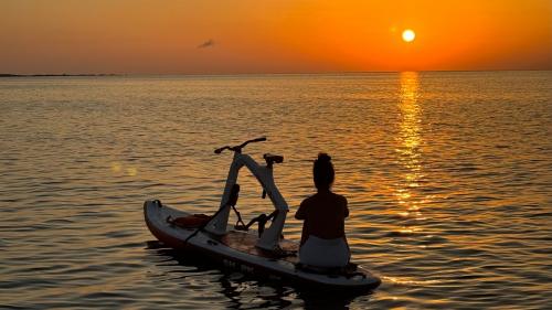 Fille sur un vélo aquatique lors d'une randonnée au lever du soleil à Stintino