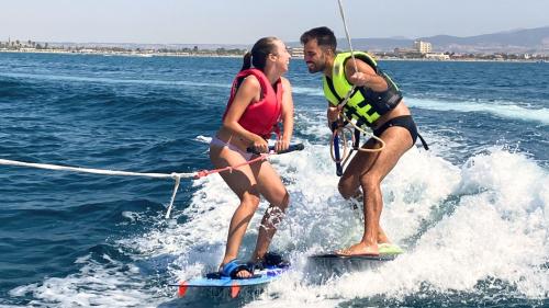 Coppia di ragazzo e ragazza durante giochi d'acqua divertenti nel Golfo di Cagliari