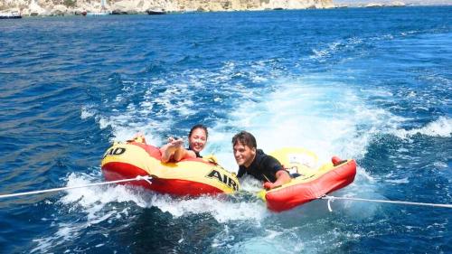 Enfants avec un beignet remorqué par un bateau dans le golfe de Cagliari