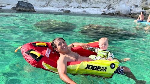 Padre e figlio giocano in acqua durante esperienza divertente a Cagliari