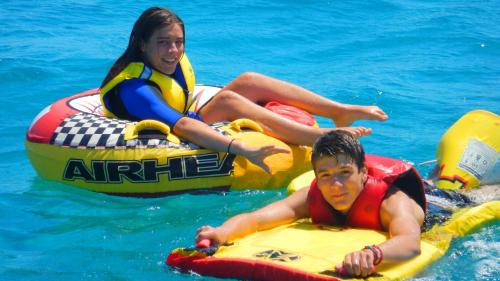 Enfants avec un beignet remorqué par un bateau dans le golfe de Cagliari