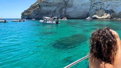 Girl on board a boat sailing in the crystal-clear waters of the Gulf of Cagliari