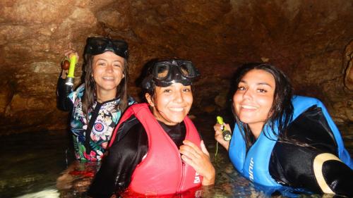 Group of girls snorkelling inside hidden caves in the Gulf of Cagliari