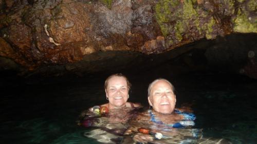 Des filles à l'intérieur d'une grotte font de la plongée avec masque et tuba à la lueur des torches.