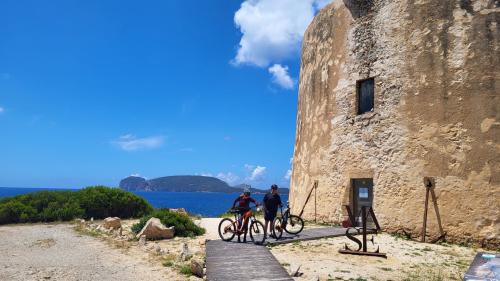 Tour avec Capo Caccia derrière elle lors d'une visite guidée en ebike pour découvrir la région d'Alghero