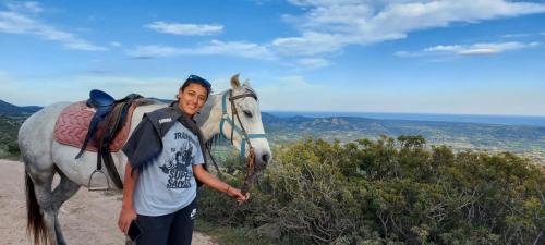 Fille avec un cheval blanc lors d'une randonnée dans la région d'Orosei