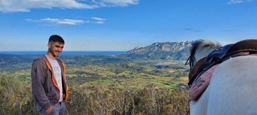 Garçon avec un cheval blanc dans les collines d'Irgoli