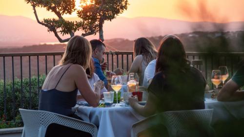 Menschen genießen eine Weinprobe auf einer Terrasse bei Sonnenuntergang im Nordosten Sardiniens