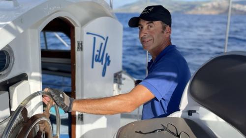 Le capitaine guide le catamaran depuis Castelsardo