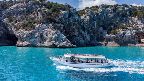 The motorboat as it sails through the crystal-clear waters of Cala Sisine in the Gulf of Orosei