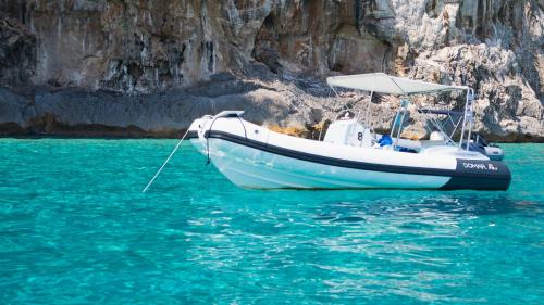 Gommone mentre naviga nelle acque di Cala Mariolu nella costa di Baunei