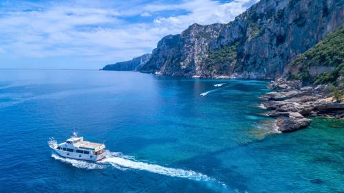 Motorship sailing in the crystal-clear waters of the Gulf of Orosei on the east coast of Sardinia