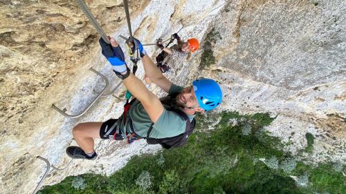 Boy climbs the rock face of the Giorré ferrata in Cargeghe