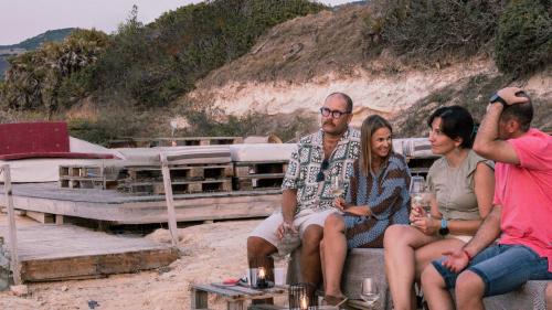 Persone mentre degustano i vini della tenuta al tramonto nel territorio di Castelsardo