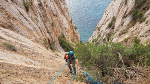 Persona mentre scende nel canale con la corda a Porto Flavia nel sud-ovest della Sardegna