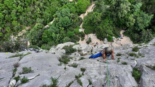 A man climbs the rock face of Aguglia di Goloritzè.